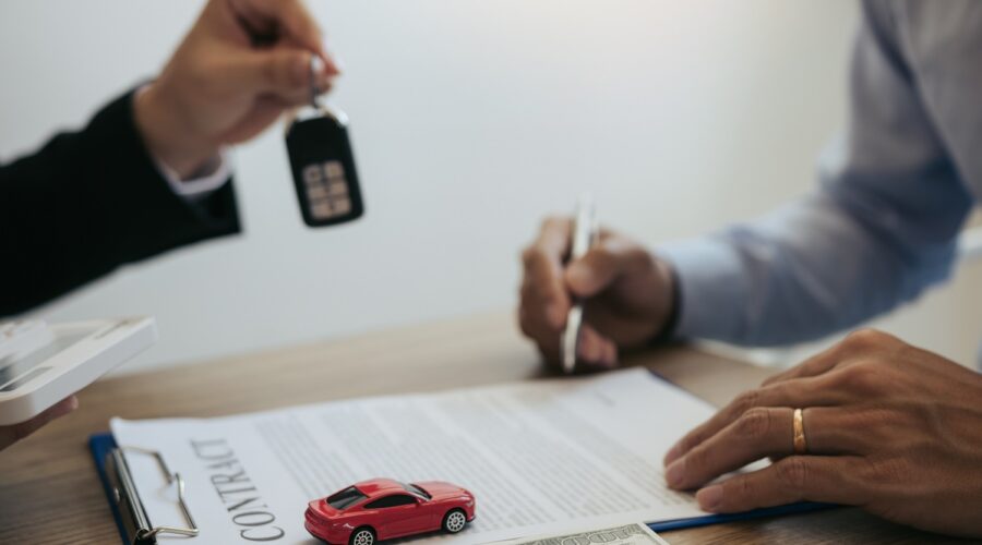 New car buyers sign contract documents for new car purchases at